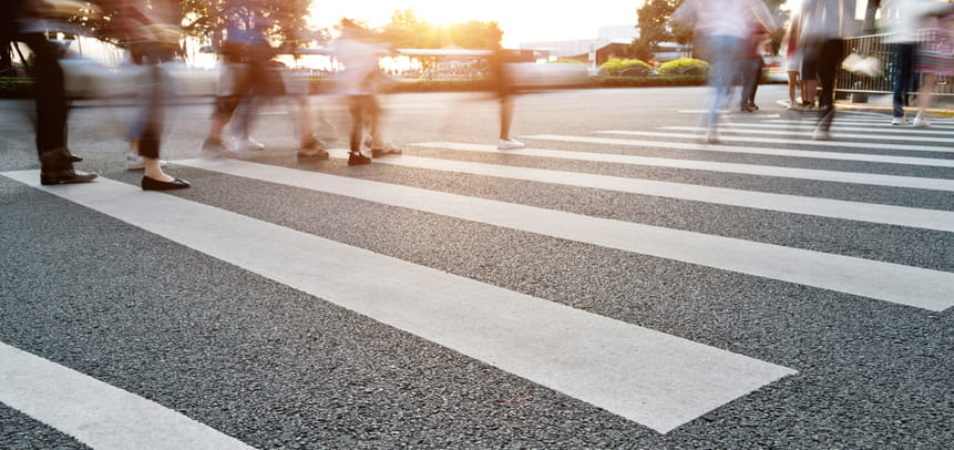 A blurry image of pedestrians crossing a crosswalk.