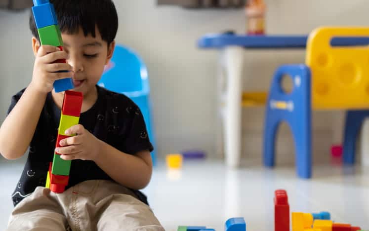 A child playing with blocks at a daycare.