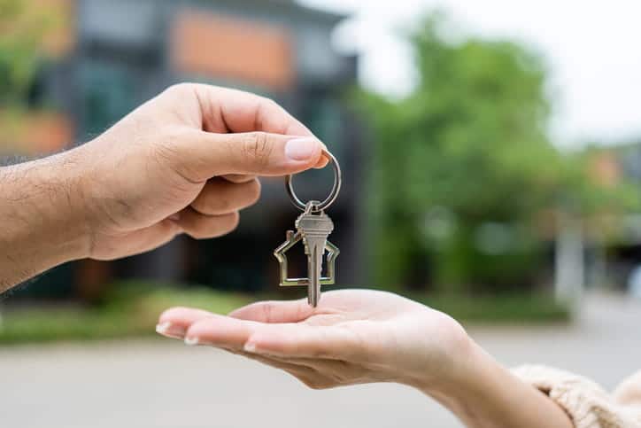 An airbnb owner handing the rental keys to a renter.