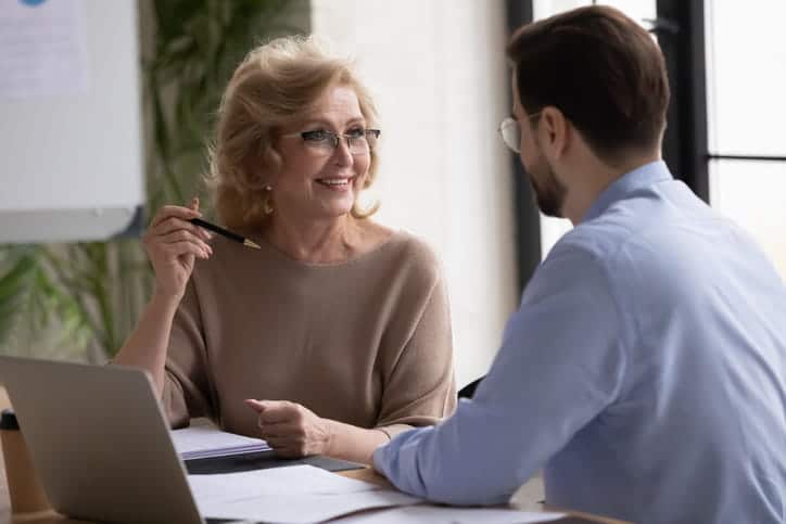 Two personal injury attorneys sit at a desk discussing a case.