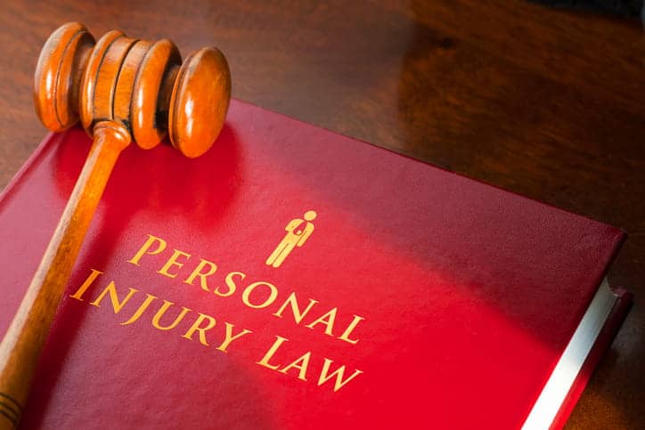 A gavel on top of a book labeled "personal injury law. "