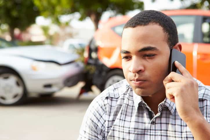 A man on the phone with his insurance company after a car accident.